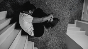 A person curled up in emotional distress and nervous system freeze, representing the heavy toll of unmanaged emotional patterns in relationships.